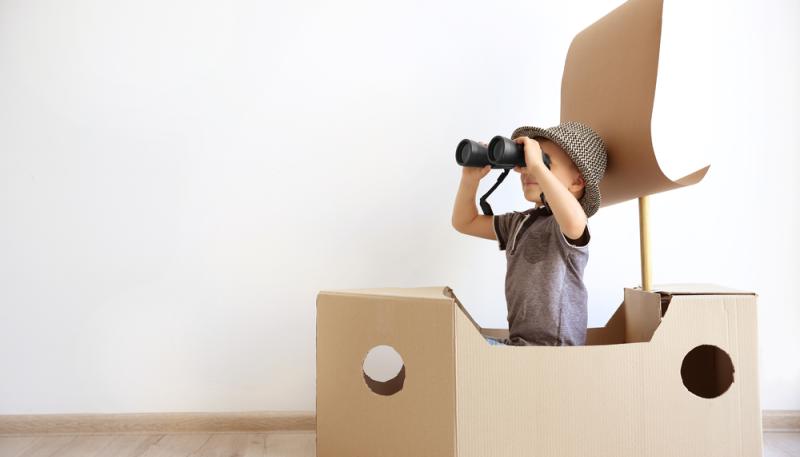 Kid playing with cardboard box