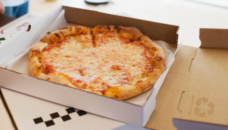 Open pizza box with a recycling reminder on the lid