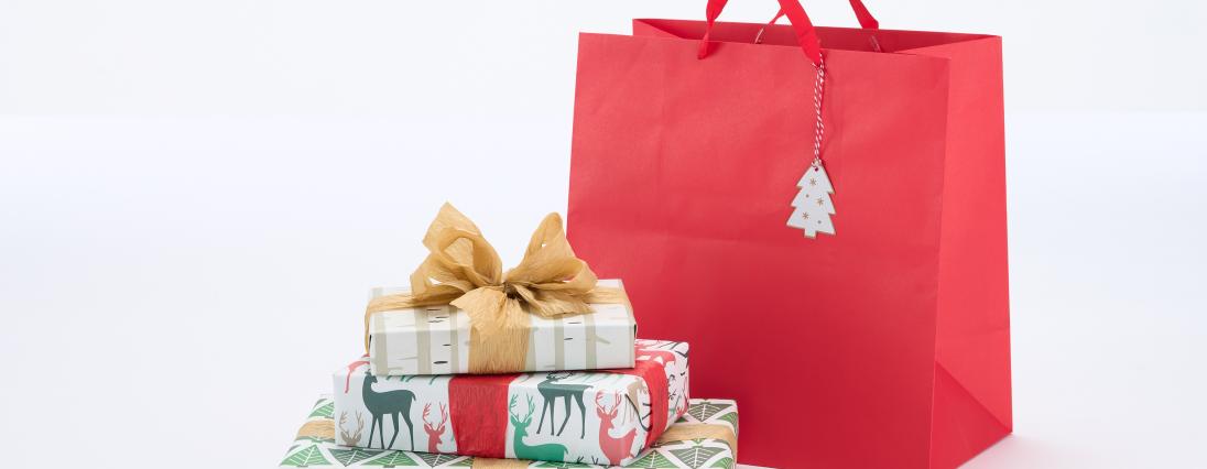 Pile of wrapped gifts and red gift bag