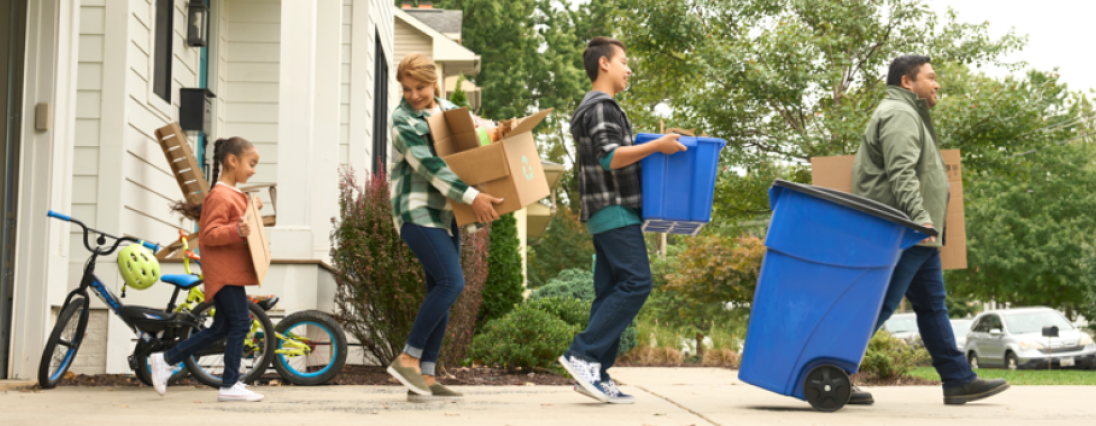 Family bringing their recycling to the curb.