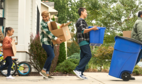Family bringing their recycling to the curb.