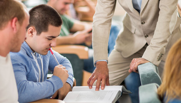 Student and teacher looking at textbook