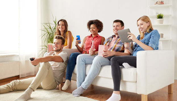 Friends watching TV, playing on phone and tablet