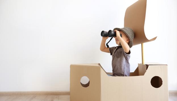 Kid playing with cardboard box