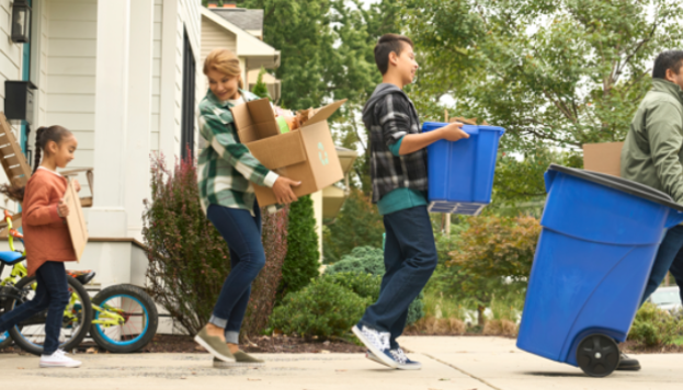 Family bringing their recycling to the curb.
