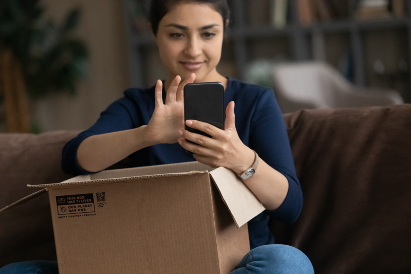 Women with box looking at her phone