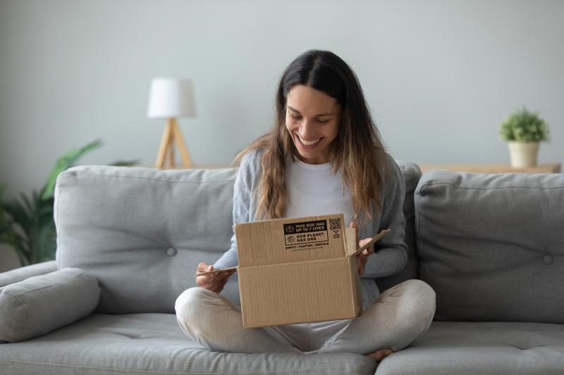 women opening cardboard box that has the box to nature mark on it